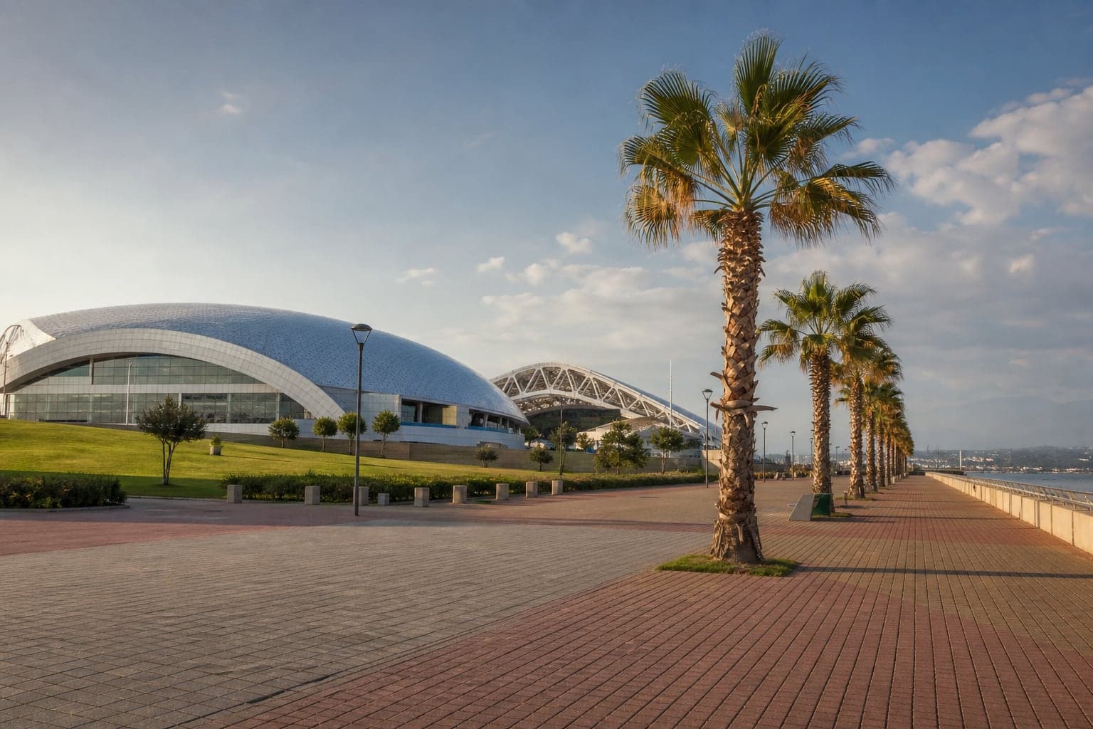 Sochi Olympic Park with arenas, promenade, and palms by the sea.