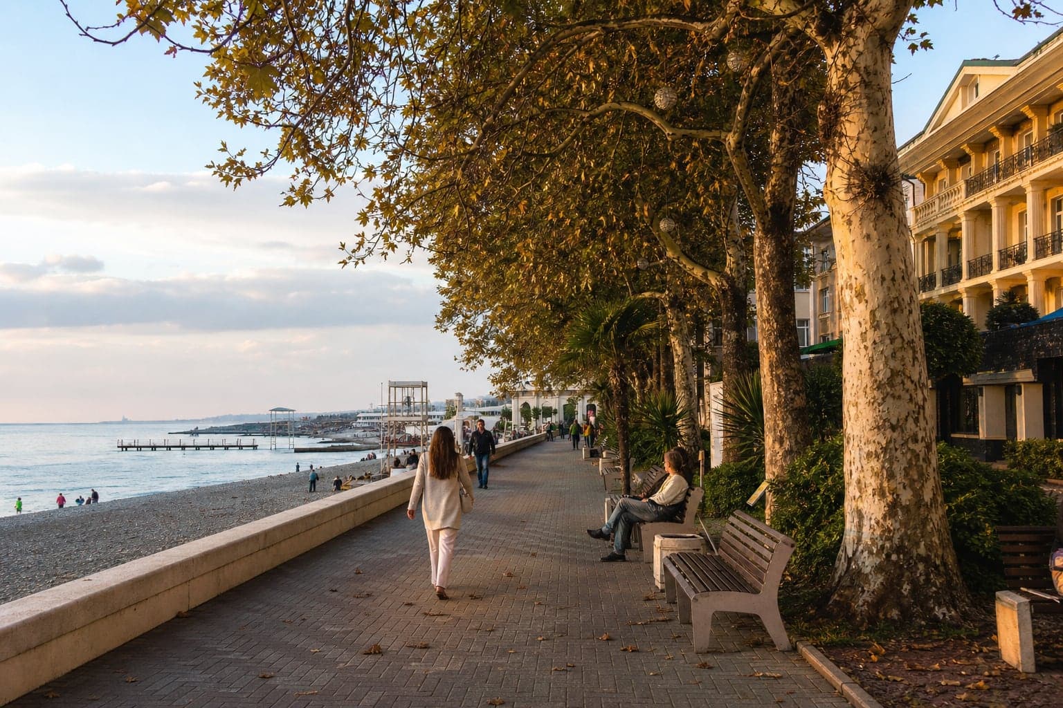 Sochi seaside promenade with palms and warm evening light.